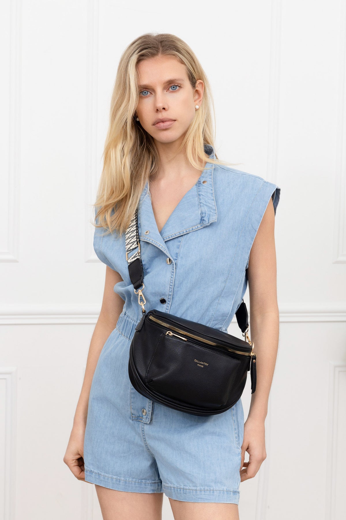 Sac Glamour Shiny noir porté en bandoulière par une femme, large sangle réglable à motif géométrique – réf. Z-83047-1