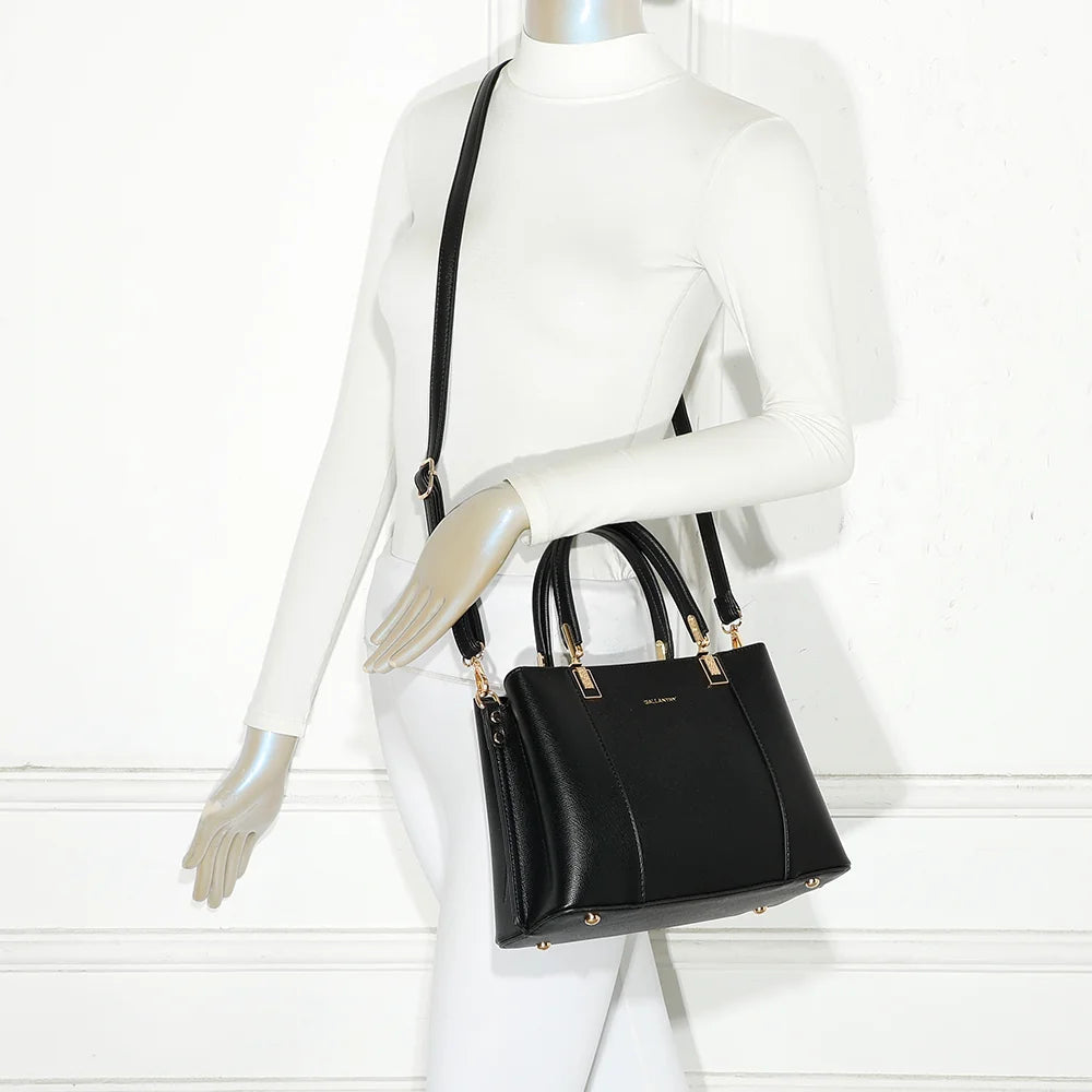Sac à main Abyss noir porté par une femme, à la main ou à l’épaule avec sa bandoulière – réf. DQ-8699