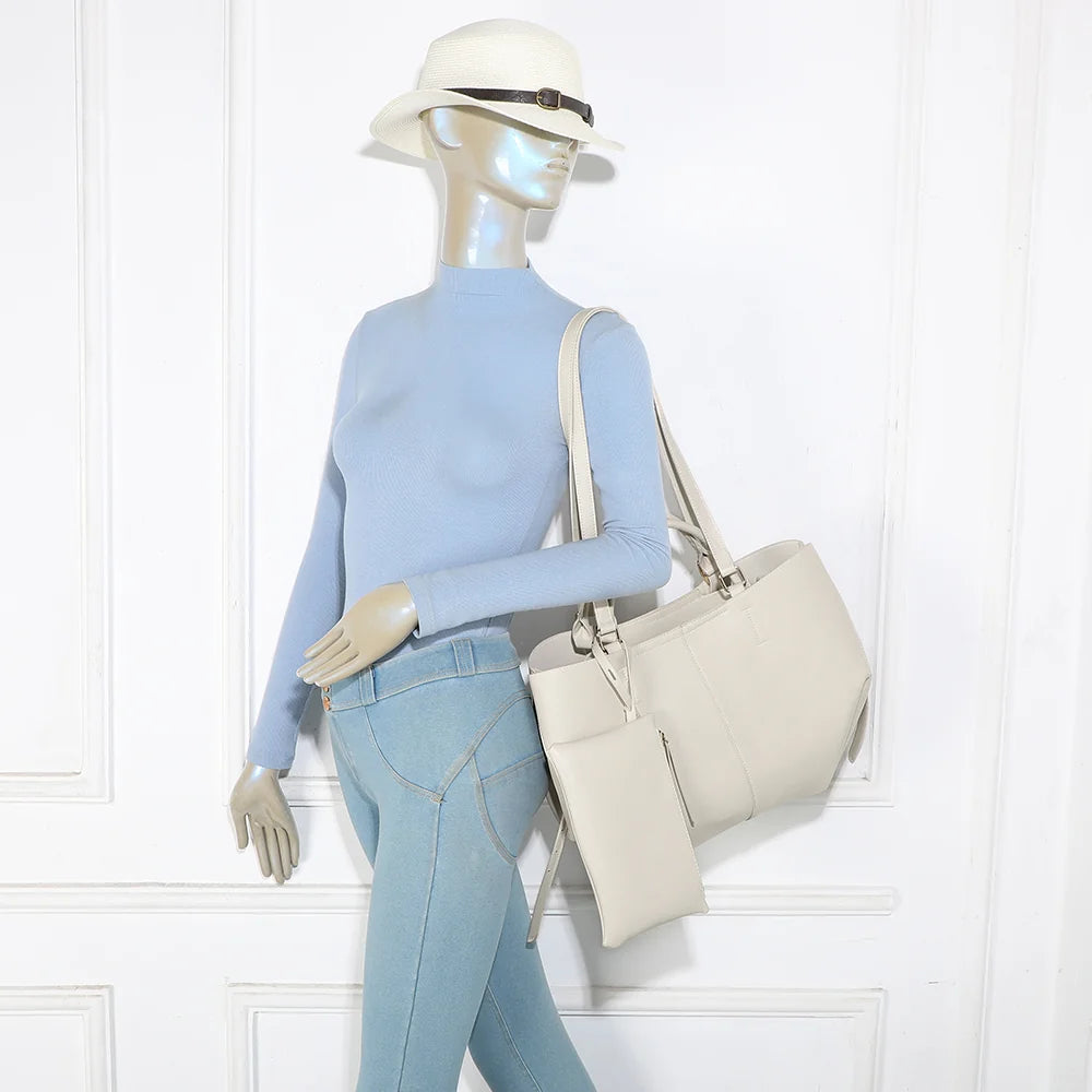Sac Adriana beige porté par une femme, à la main ou à l’épaule grâce à ses deux paires d’anses – réf. R-1996
