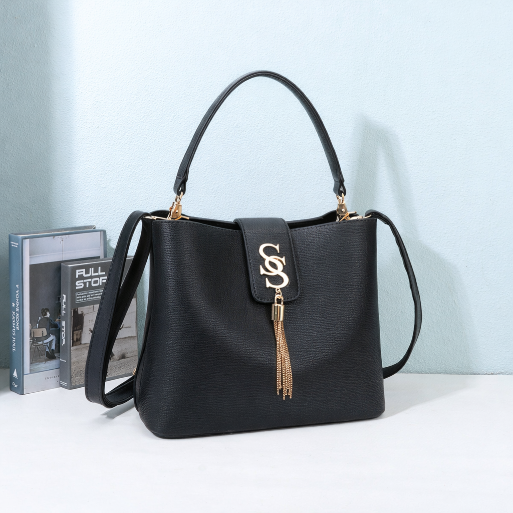 Sac à main Amélia noir avec logo doré et pompon à franges, mis en scène dans un décor – visuel d’ambiance créé avec l’IA – Gallantry Paris