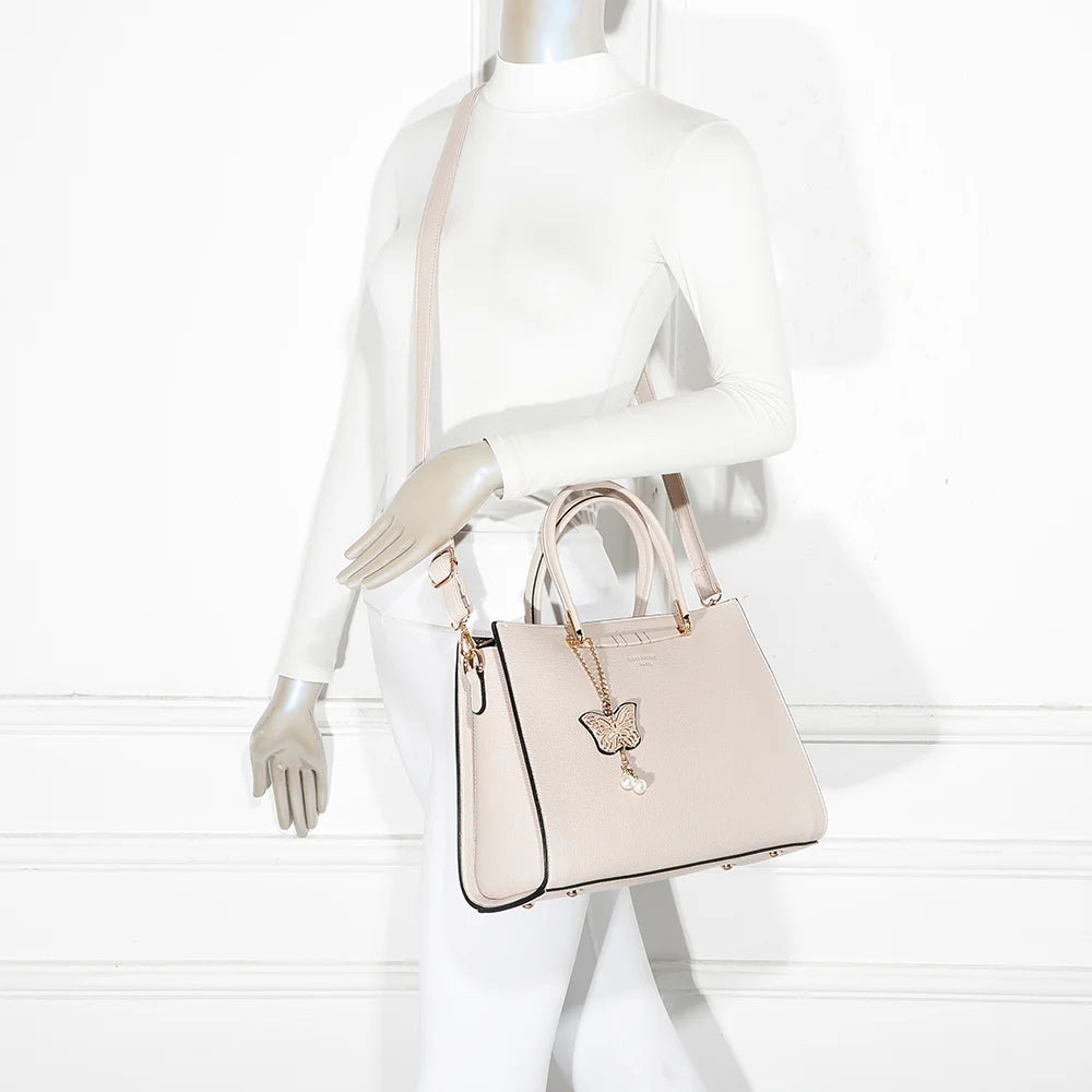 Sac à main Ariane beige porté par une femme, à la main ou à l’épaule avec sa bandoulière amovible – réf. R-1973