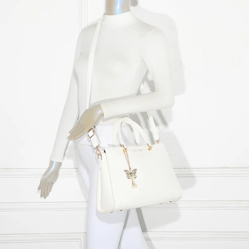 Sac à main Ariane blanc porté par une femme, à la main ou à l’épaule avec sa bandoulière amovible – réf. R-1973