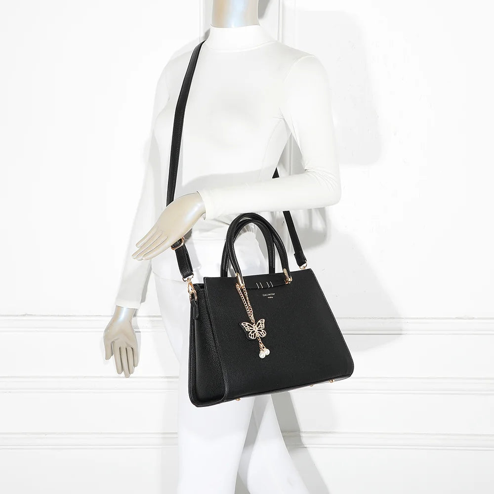 Sac à main Ariane noir porté par une femme, à la main ou à l’épaule avec sa bandoulière amovible – réf. R-1973