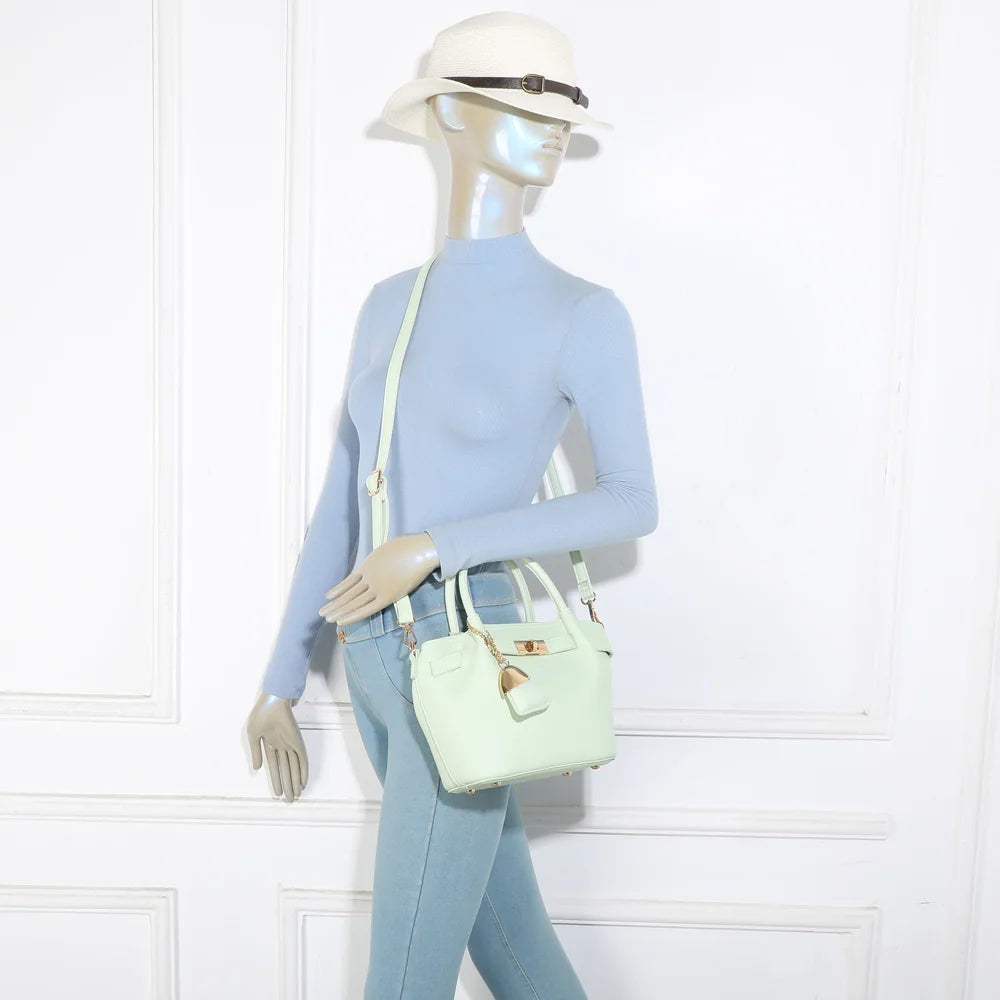 Sac Blossom vert clair porté par une femme, à la main ou à l’épaule grâce à sa bandoulière amovible – réf. A-9149