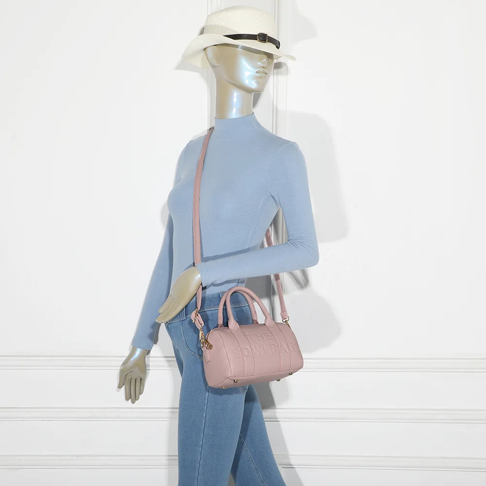 Bowlbag mini rose porté par une femme, à la main ou avec sa bandoulière amovible et réglable – réf. R-1995