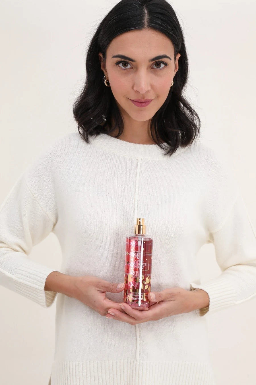 Femme vaporisant la brume parfumée Delicate Oasis sur ses cheveux