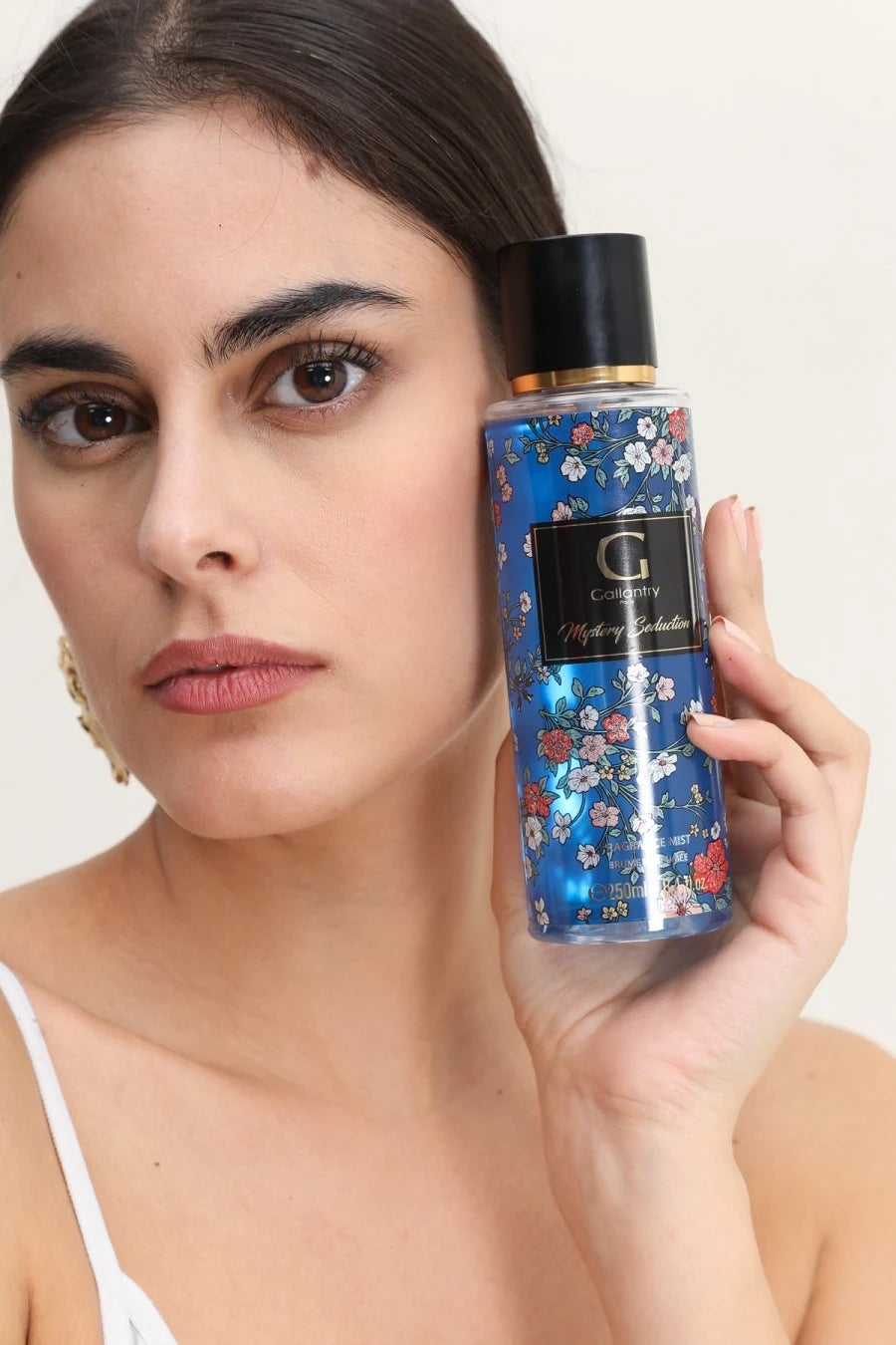Femme vaporisant la brume parfumée Mystery Seduction de Gallantry dans ses cheveux