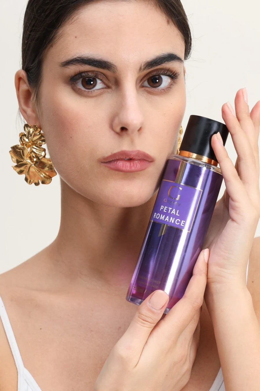 Femme vaporisant la brume parfumée Petal Romance sur ses cheveux