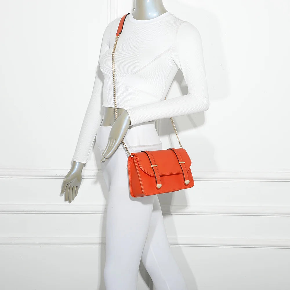Sac Chic Intemporel orange porté par une femme, chaîne dorée à l’épaule ou en travers – réf. C-0156