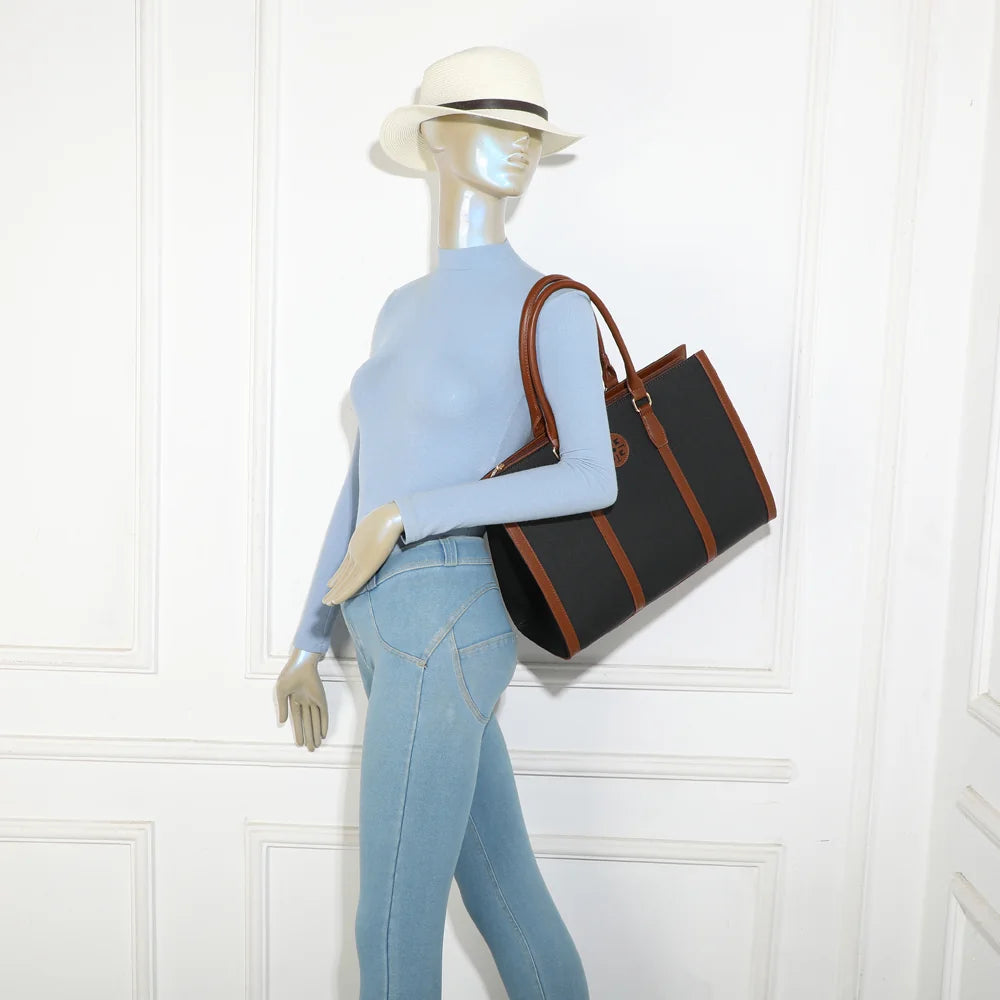 Sac Clara Duo noir porté par une femme, anses rigides en main ou bandoulière amovible
