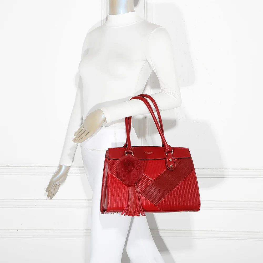 Sac Cléo rouge foncé porté par une femme, à la main ou à l’épaule grâce à sa bandoulière réglable – réf. R-1501-4