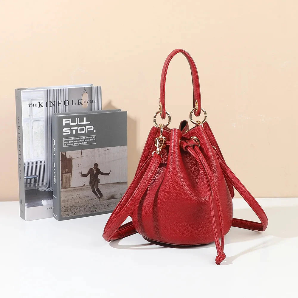 Sac seau femme Éclat de Rêve rouge posé devant des livres – visuel d'ambiance créé avec l'IA – Gallantry Paris