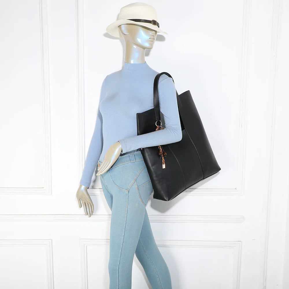 Sac cabas Erythéa noir porté à l’épaule par une femme grâce à ses anses de 31 cm – réf. R-2027
