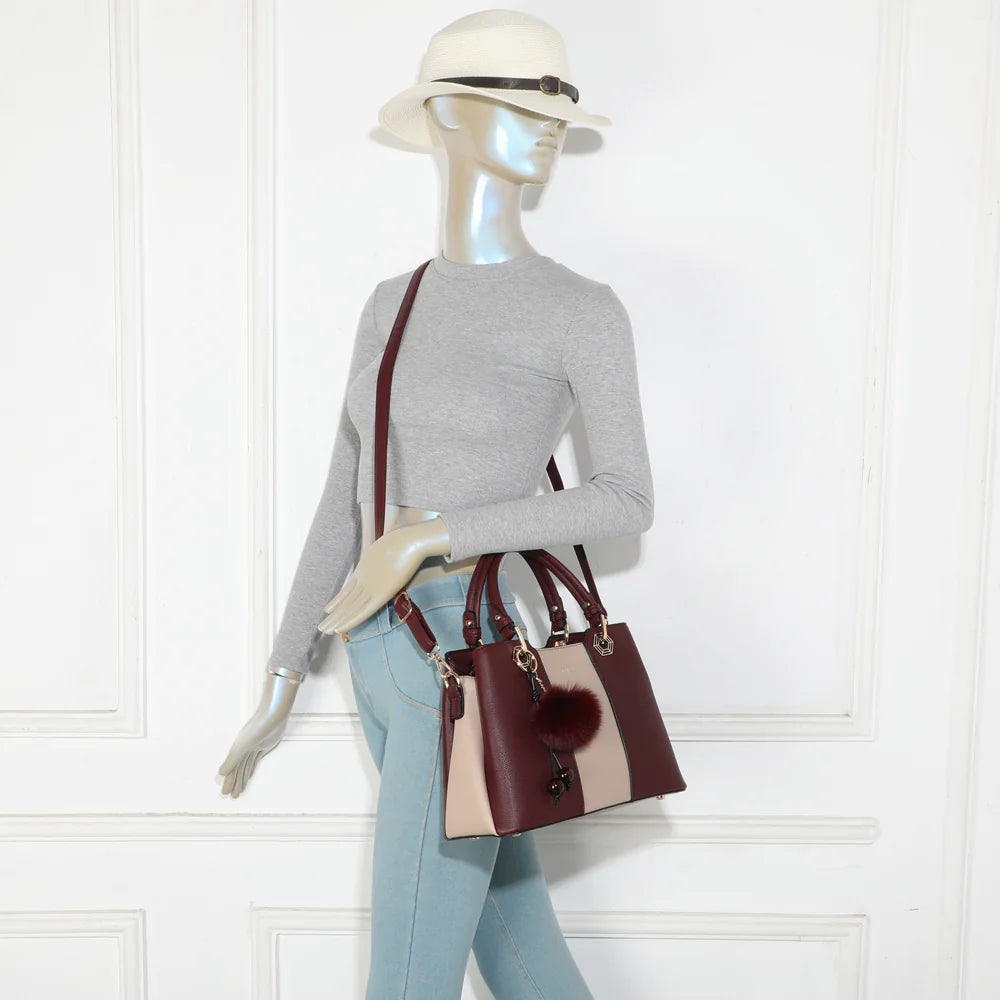 Fiora Pop bordeaux porté par une femme, à la main ou à l’épaule grâce à sa bandoulière ajustable – réf. M-9354-3