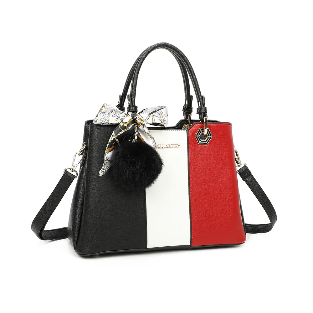 Fiora Pop noir/rouge vu de trois quarts : silhouette structurée, quincaillerie dorée hexagonale et pompon – réf. M-9354-3