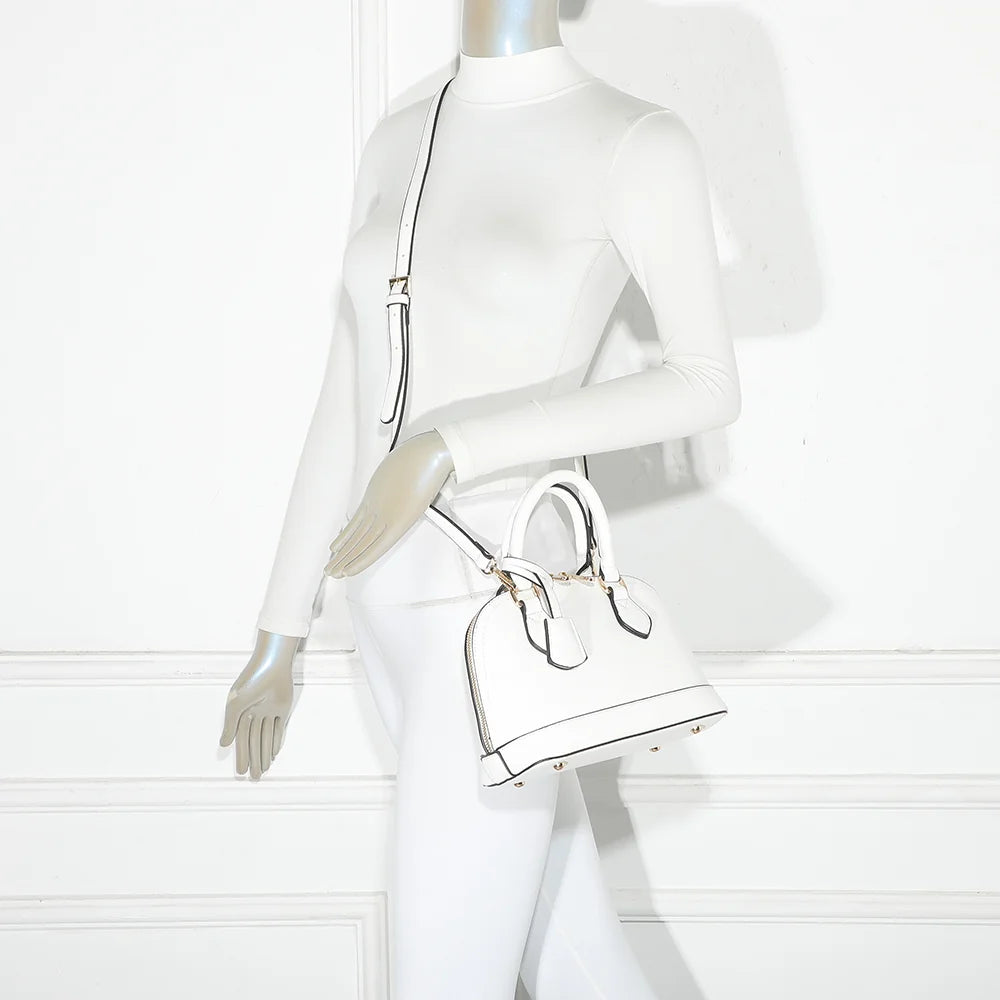 L'Éclat Mini blanc porté à la main par une femme, un petit sac bombé qui habille une tenue simple – réf. DQ-8596-5