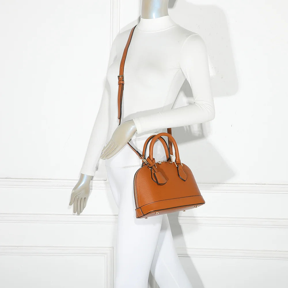 L'Éclat Mini camel porté à la main par une femme, un petit sac bombé qui habille une tenue simple – réf. DQ-8596-5