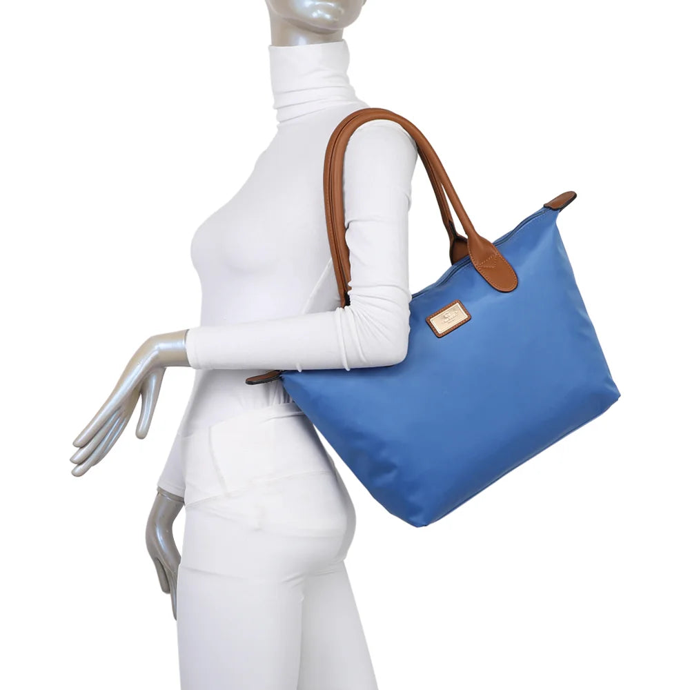 La Balade Medium bleu royal portée par une femme : un sac cabas au format medium avec deux anses marron – réf. Z-03