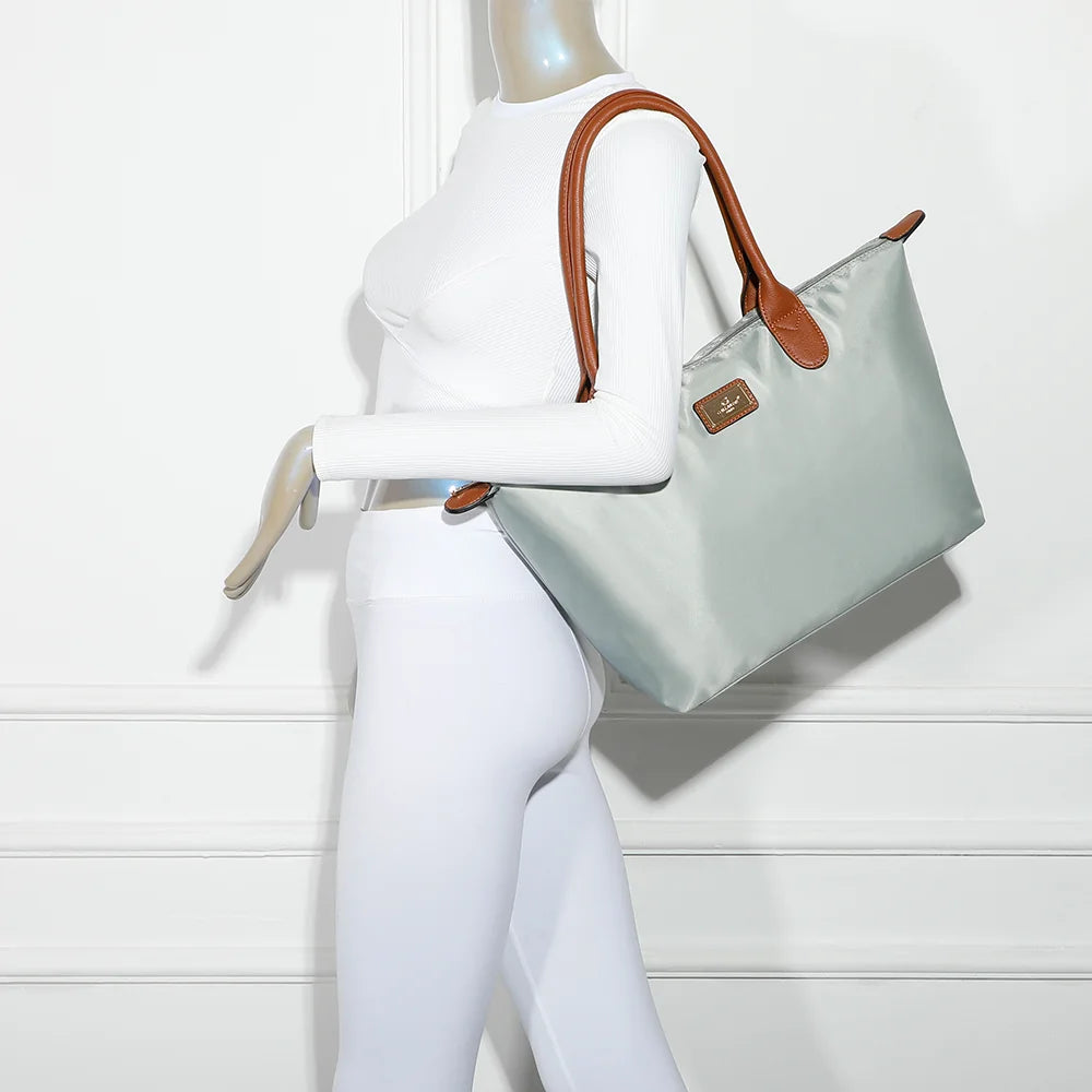 La Balade Medium gris claire portée par une femme : un sac cabas au format medium avec deux anses marron – réf. Z-03