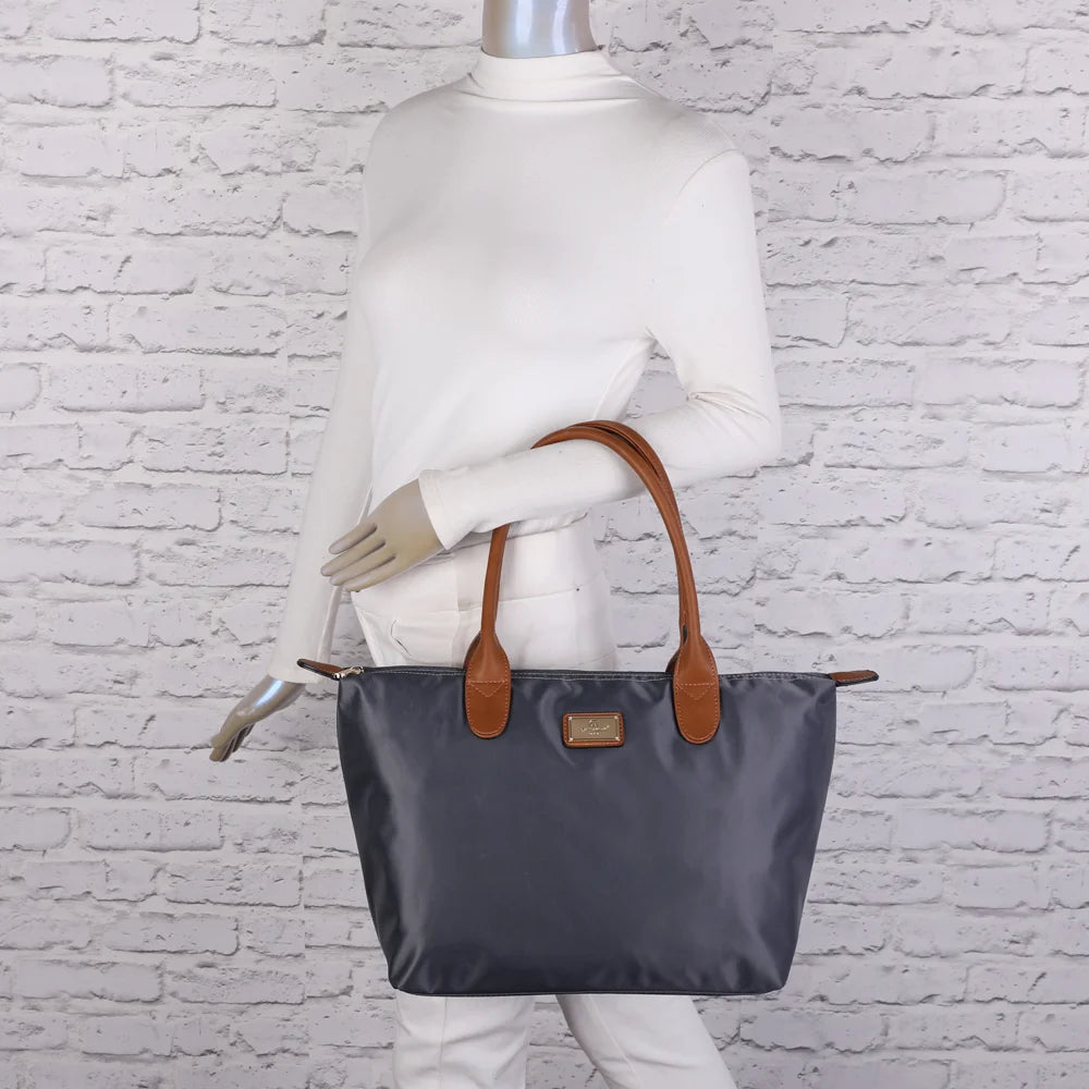 La Balade Medium gris foncé portée par une femme : un sac cabas au format medium avec deux anses marron – réf. Z-03