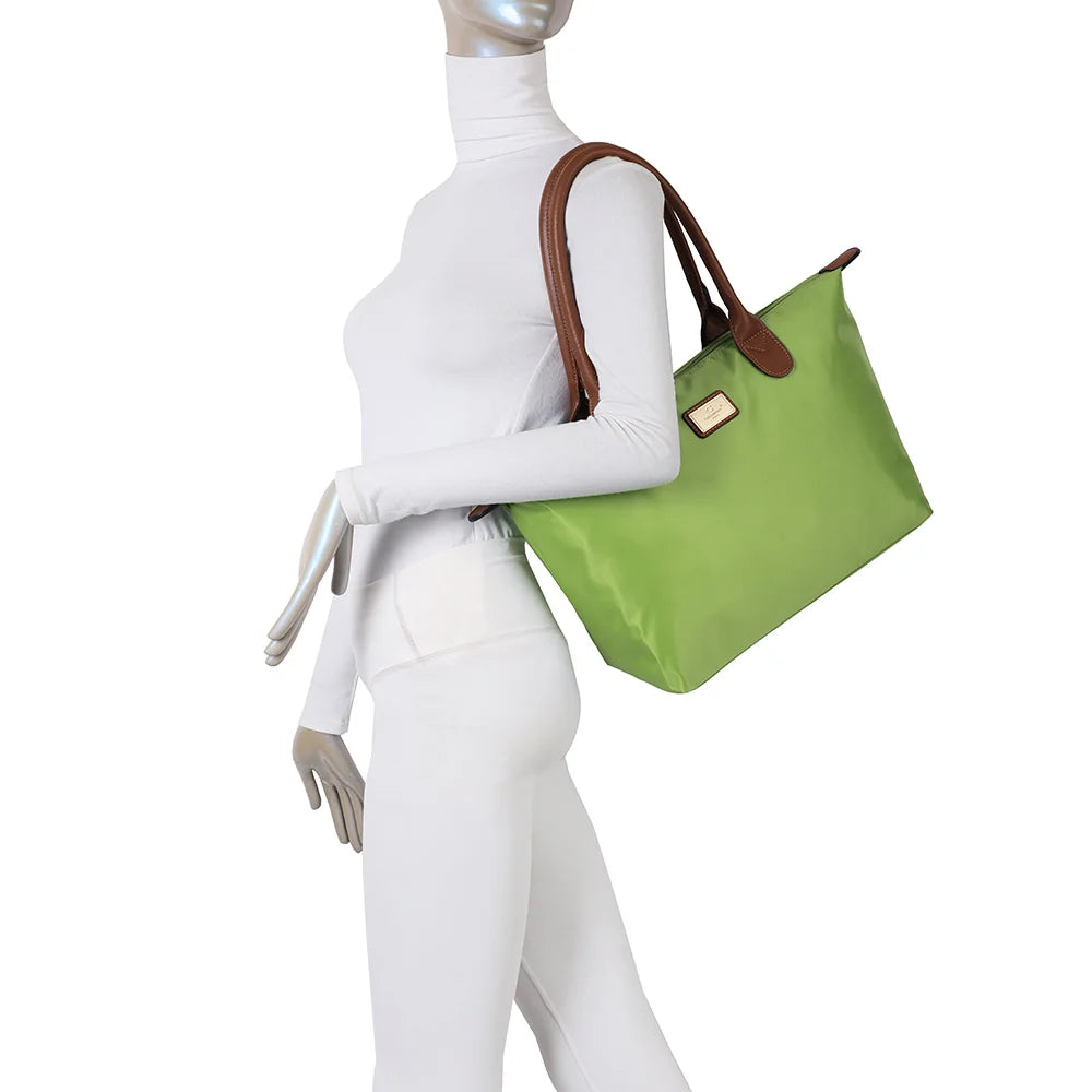 La Balade Medium vert pomme portée par une femme : un sac cabas au format medium avec deux anses marron – réf. Z-03
