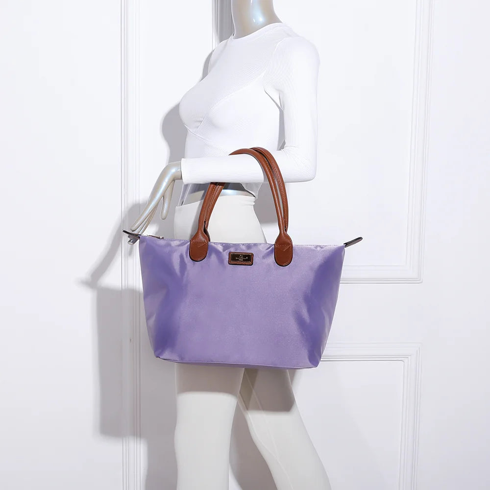 La Balade Medium violet claire portée par une femme : un sac cabas au format medium avec deux anses marron – réf. Z-03