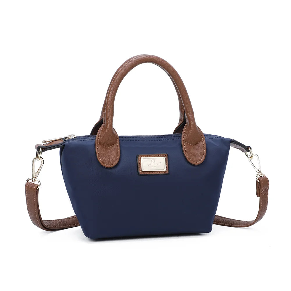 La Balade (Mini) marine vu de trois quarts : silhouette compacte évasée et attaches latérales à anneaux dorés – réf. Z-05