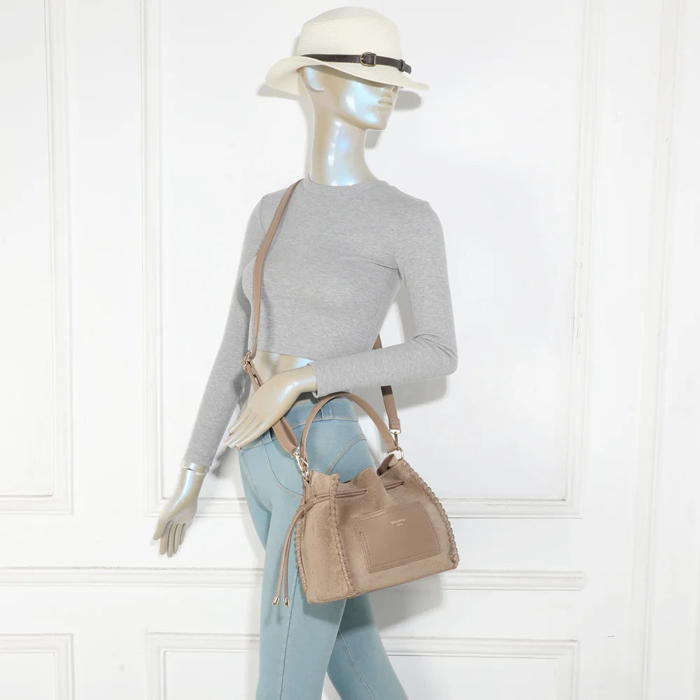 Sac La Belmira taupe foncé porté par une femme, à la main ou avec sa bandoulière amovible – réf. R-2073