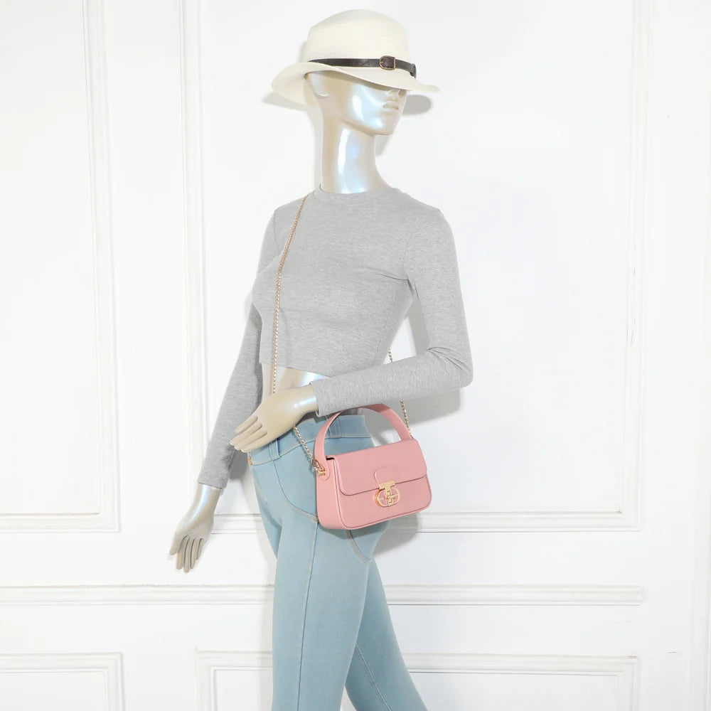 Sac La Caliane rose porté par une femme, à la main ou avec sa chaîne dorée – réf. YL-26023