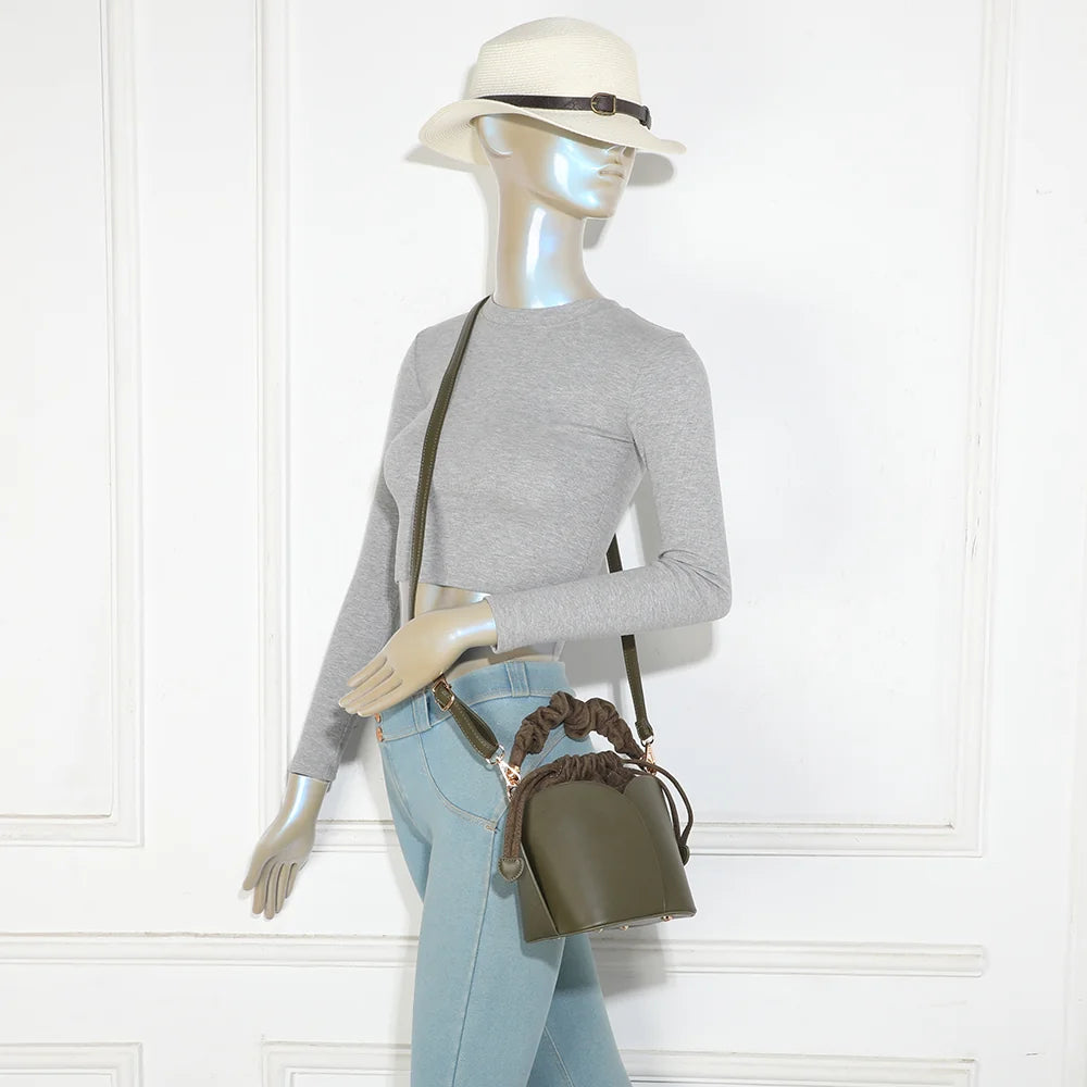 Sac La Nuvia vert foncé porté par une femme, à la main par sa poignée froncée ou en bandoulière – réf. DQ-8727