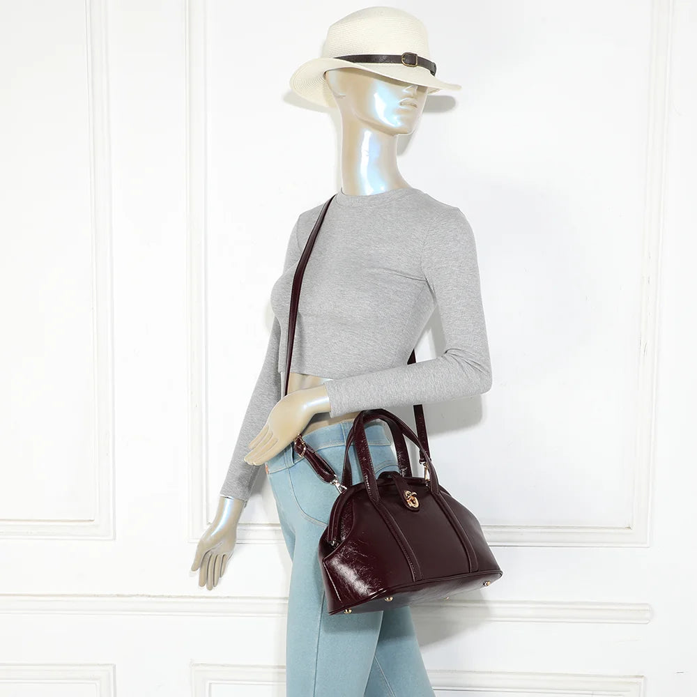 Sac La Parure bordeaux porté par une femme, tenu à la main par ses deux anses surpiquées – réf. R-2065