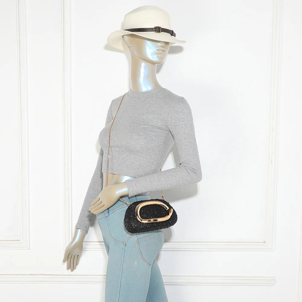 Pochette La Pépite noir portée par une femme, à la main ou avec sa fine chaîne métallique – réf. HR-92009-3