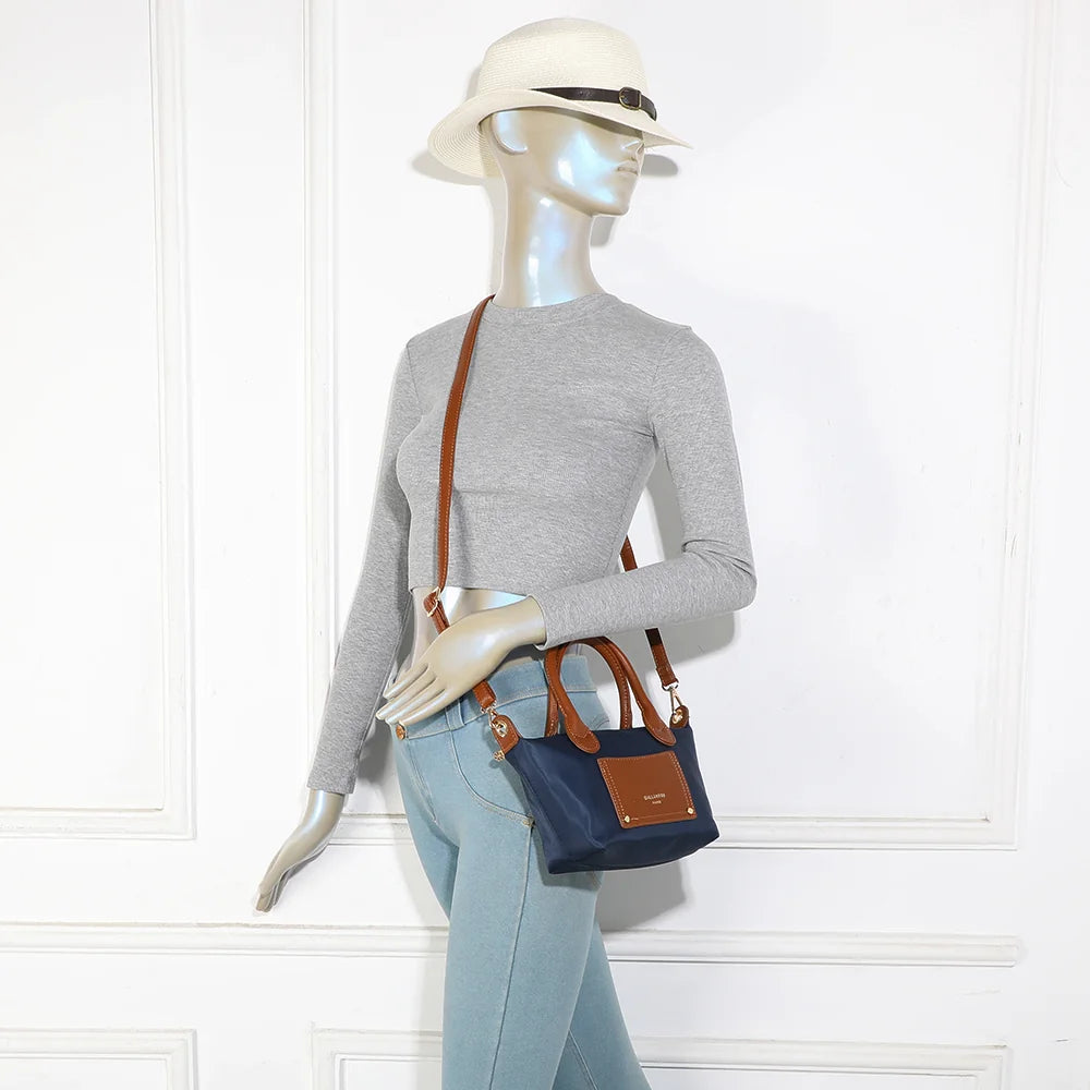 La Romane bleu foncé portée par une femme, à la main par ses anses cognac ou à l’épaule – réf. Z-05-6