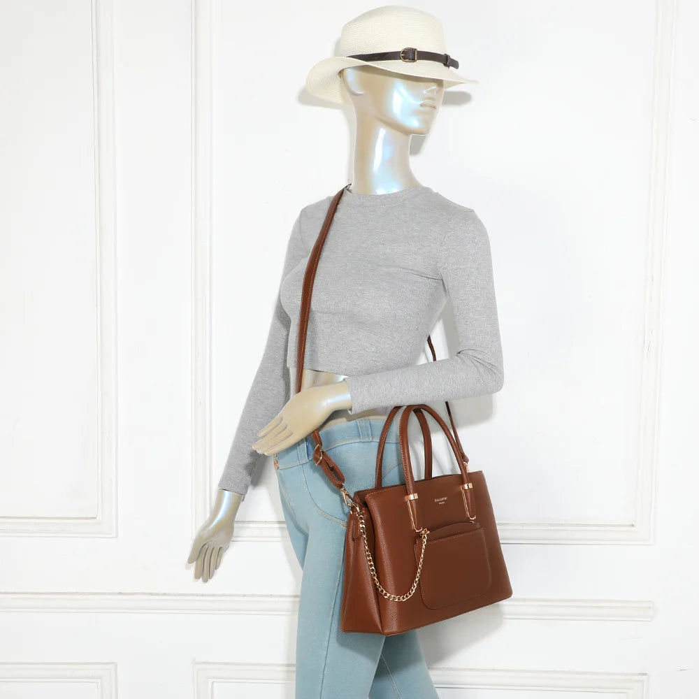 Sac à main La Valdine marron foncé porté par une femme, à la main ou avec sa bandoulière – réf. M-9464