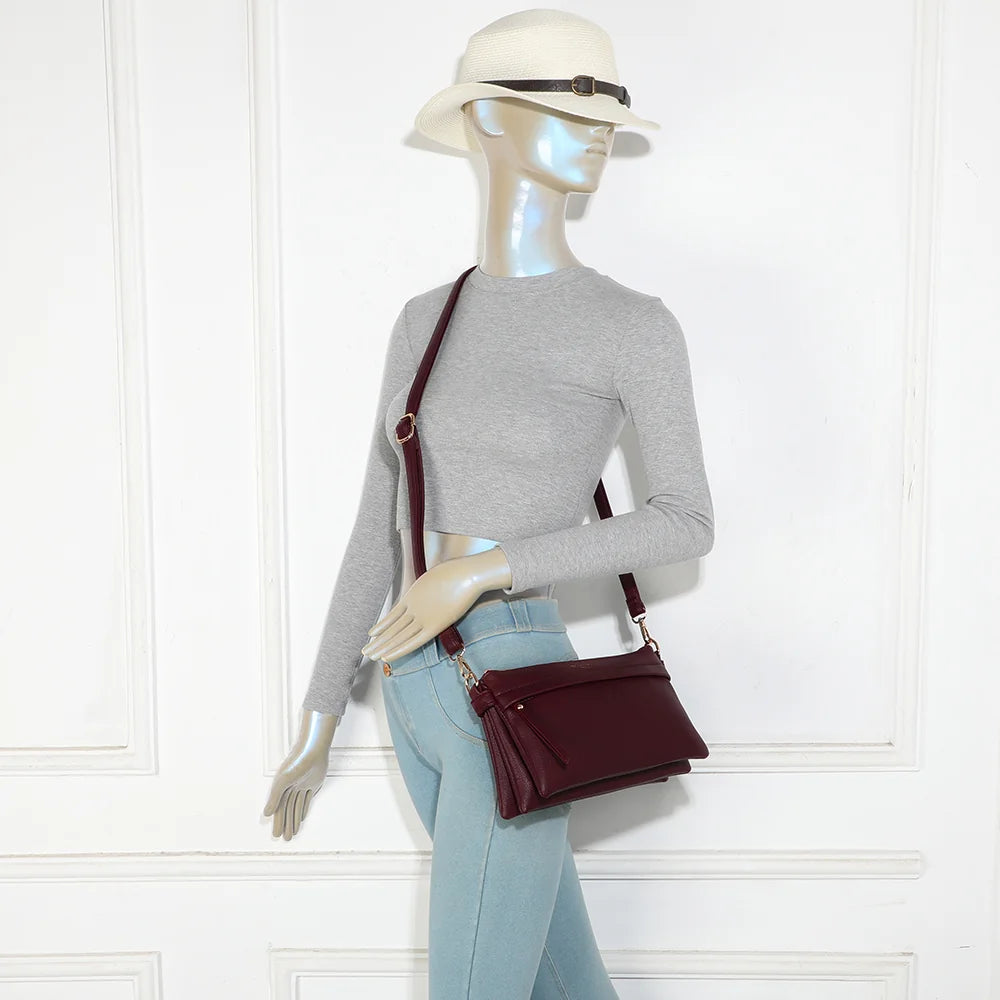 Sac bandoulière La Vélane bordeaux porté en travers du corps par une femme, bandoulière réglable – réf. A-9176