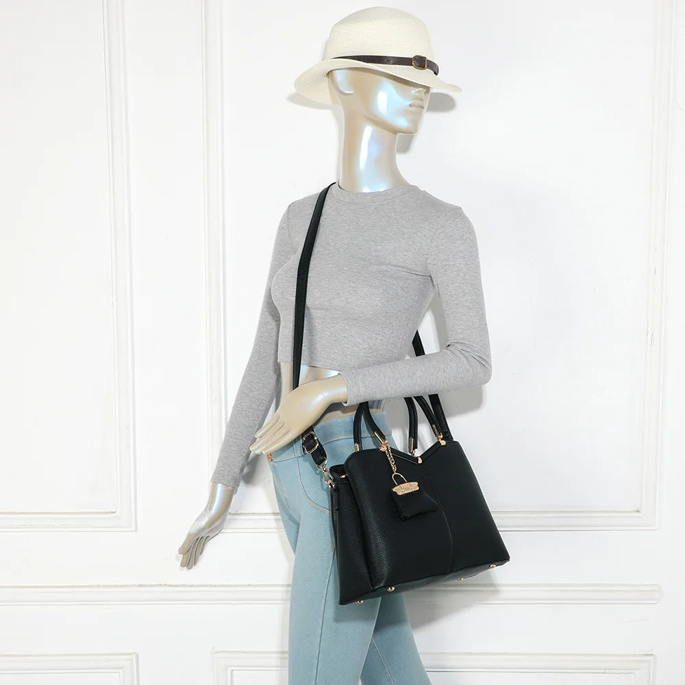 Sac à main femme La Vérone noir porté à la main, charm doré bien visible – réf. M-9130-1