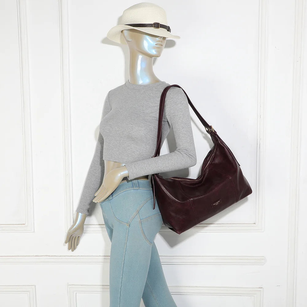 Sac Le Brumaire bordeaux porté à l’épaule par une femme, anses ajustées par boucles dorées – réf. JC-53012