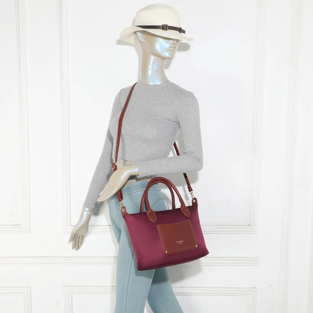 Le Cassien bordeaux porté par une femme, à la main ou en bandoulière grâce à sa sangle amovible – réf. Z-07-1
