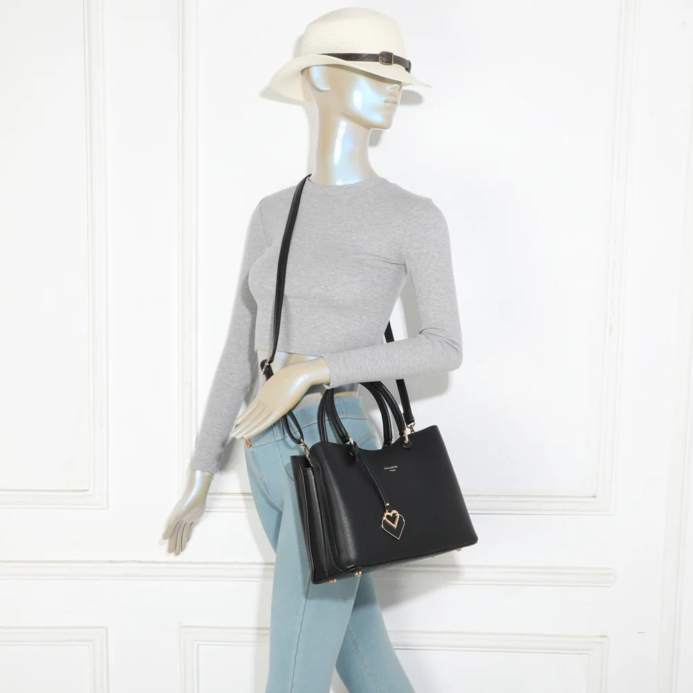 Sac à main Le Lazare noir porté par une femme, à la main ou à l’épaule avec ses deux anses – réf. G-7510