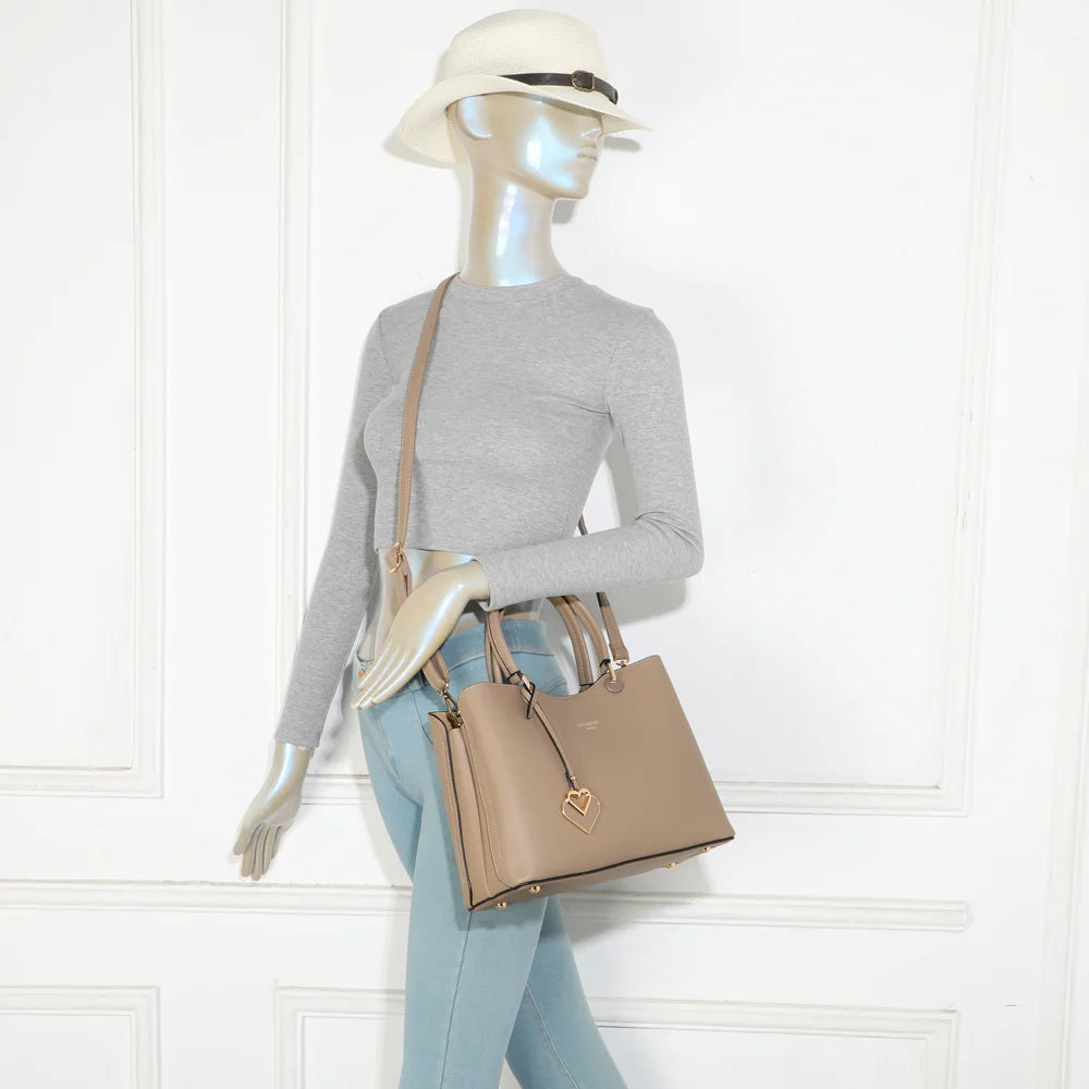 Sac à main Le Lazare taupe foncé porté par une femme, à la main ou à l’épaule avec ses deux anses – réf. G-7510