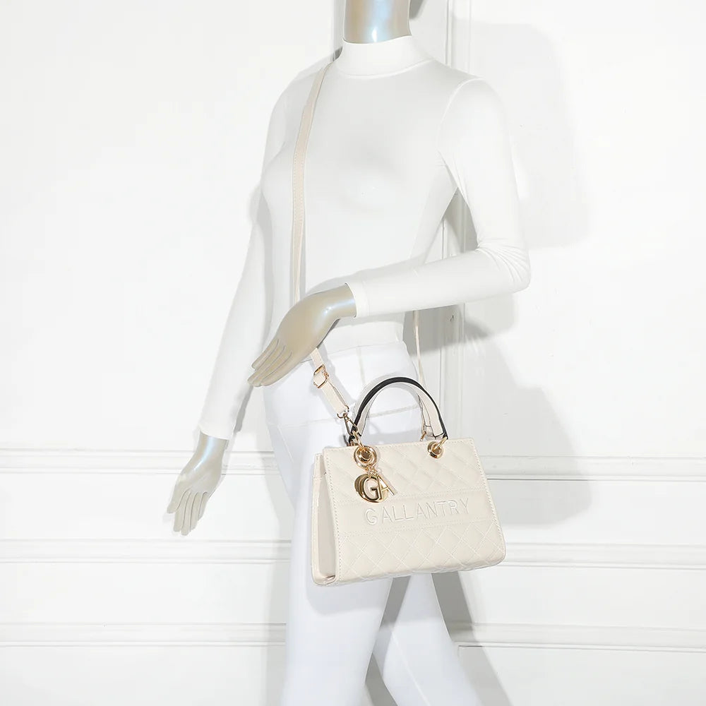 Le Matelassé Chic beige porté par une femme, à la main ou en bandoulière avec sa sangle amovible – réf. C-0169-1