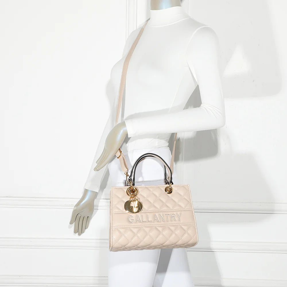 Le Matelassé beige porté par une femme, à la main ou en bandoulière avec sa sangle amovible – réf. C-0169