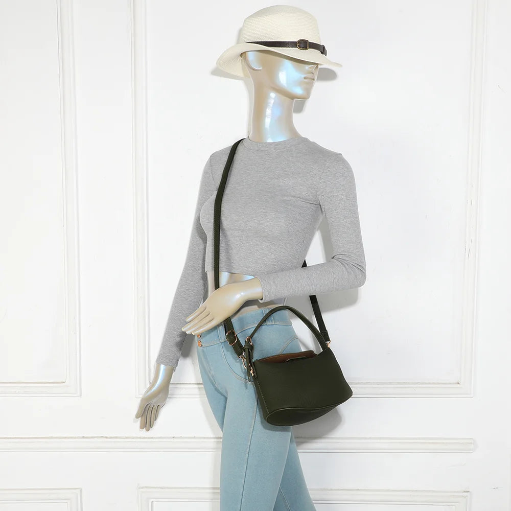 Le Mélaris vert foncé porté par une femme : petit sac à main à l’épaule ou en bandoulière amovible – réf. A-9182