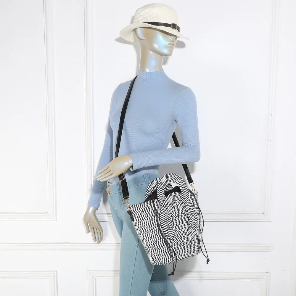 Sac Le Ondina noir/blanc porté par une femme, à la main ou en bandoulière grâce à sa sangle amovible – réf. A-9167