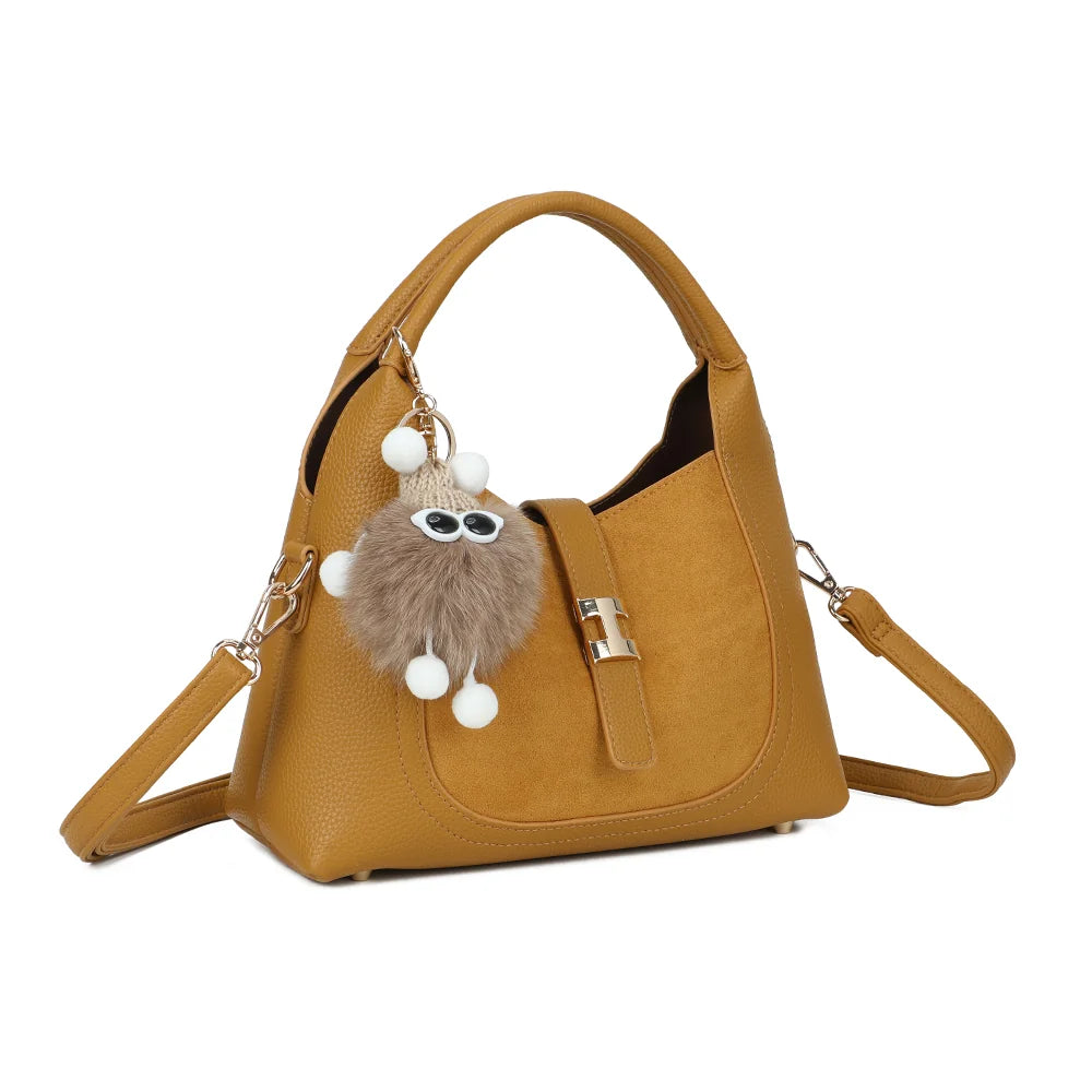 Le Santal jaune foncé de trois quarts : silhouette arrondie, patte à fermoir doré et pompon décoratif – réf. KJ-62089-1