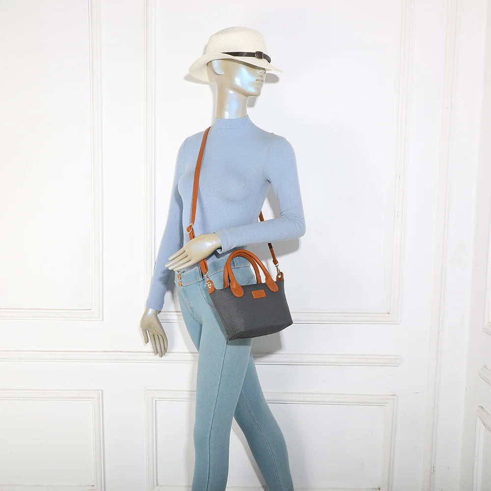 Le Soléa noir/marron porté par une femme, à la main ou en bandoulière croisée grâce à sa sangle amovible – réf. Z-05-5