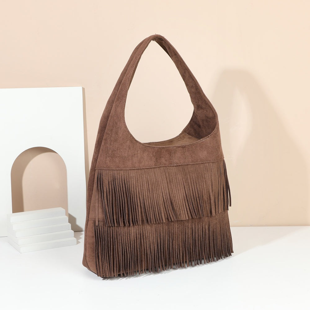 Sac hobo Ondaya Coffee à franges en suédine posé dans un décor chaleureux – visuel d’ambiance créé avec l’IA – Gallantry Paris