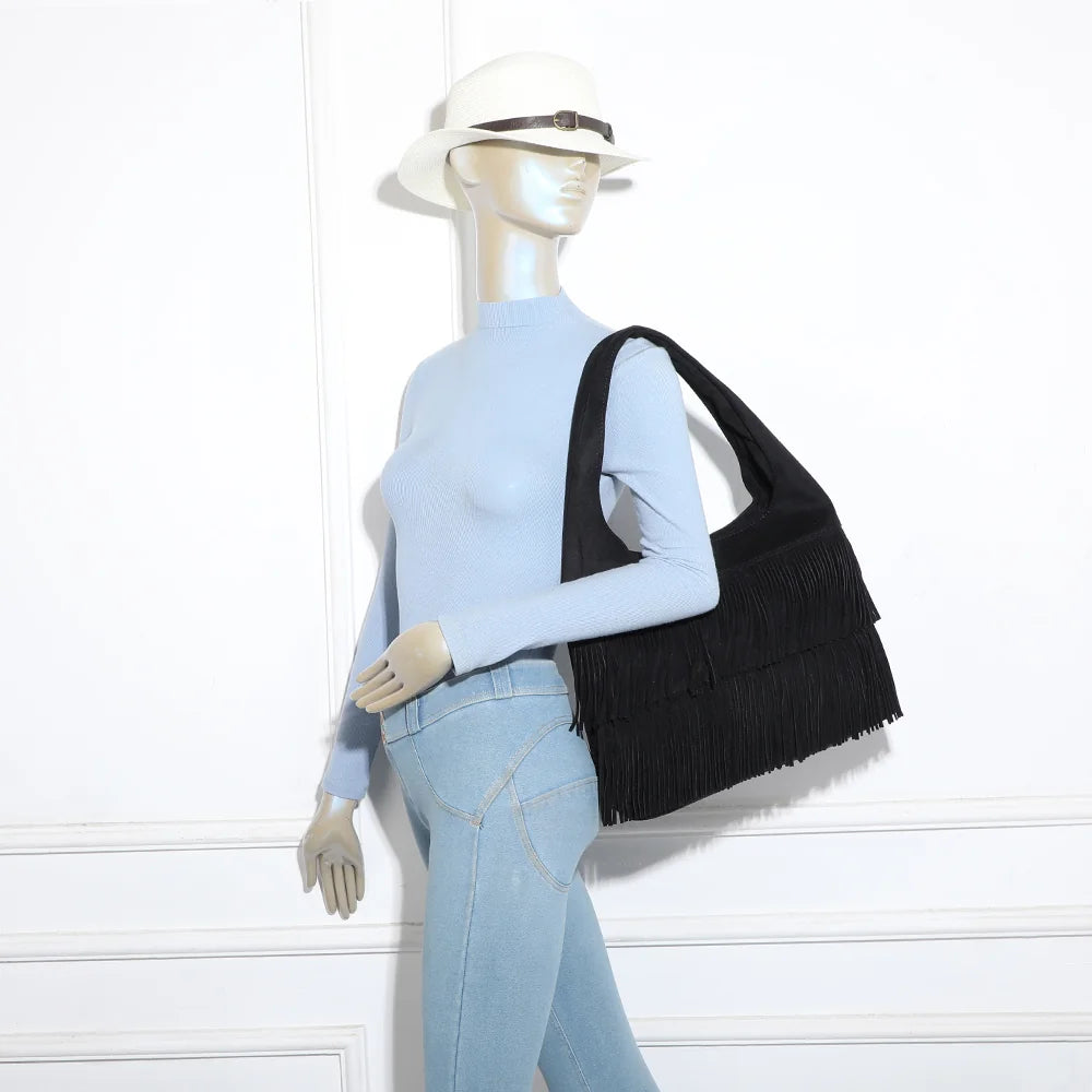 Sac hobo Ondaya noir porté à l’épaule par une femme, franges en mouvement au fil des pas – réf. M-9453