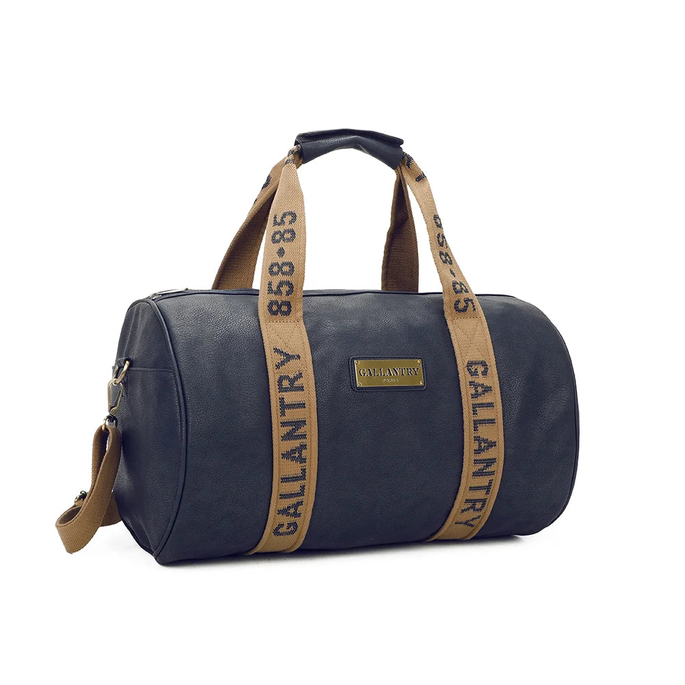 Polochon bleu marine de trois quarts : forme cylindrique, plaque logo dorée et bandoulière textile amovible – réf. Z-83049