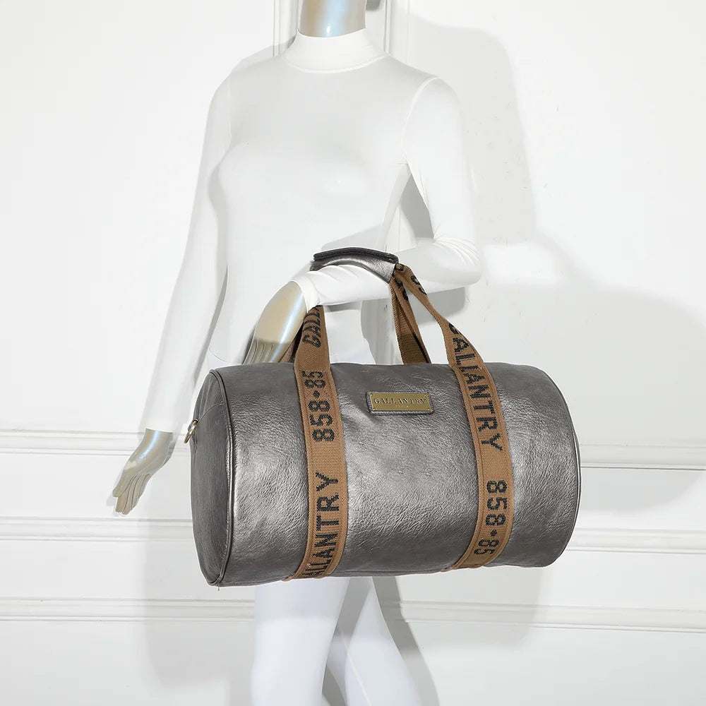 Sac de voyage Polochon gris argenté porté à l’épaule par une femme grâce à sa bandoulière amovible – réf. Z-83049
